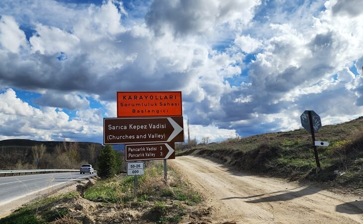 Sarıca Kepez Vadisi ve Pancarlık Vadisi yönlendirme tabelaları; Kapadokya’da toprak yol ve açık vadi manzarası